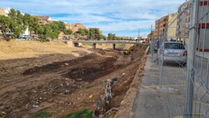 Abflusskanal in Valencia voller verschmutzter Erde, Brücke im Hintergrund